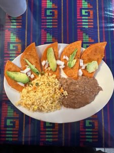 A plate of Enchiladas Potosinas, refried beans, and rice served at Casa Bakery & Restaurant in Houston, Texas.